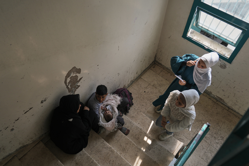 Palestinians wait to receive vaccinations for their children at a health center in Gaza City, Sunday, Nov. 9, 2025. (AP Photo/Jehad Alshrafi)