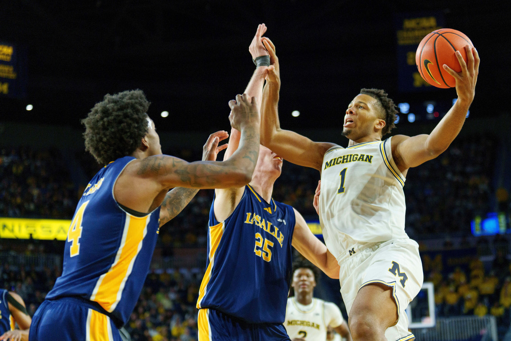 Michigan guard Trey McKenney (1) looks to shoot over La Salle guard Truth Harris (4) and forward Bowyn Beatty (25) during the second half of an NCAA college basketball game, Sunday, Dec. 21, 2025, in Ann Arbor, Mich. (AP Photo/Josh Boland)