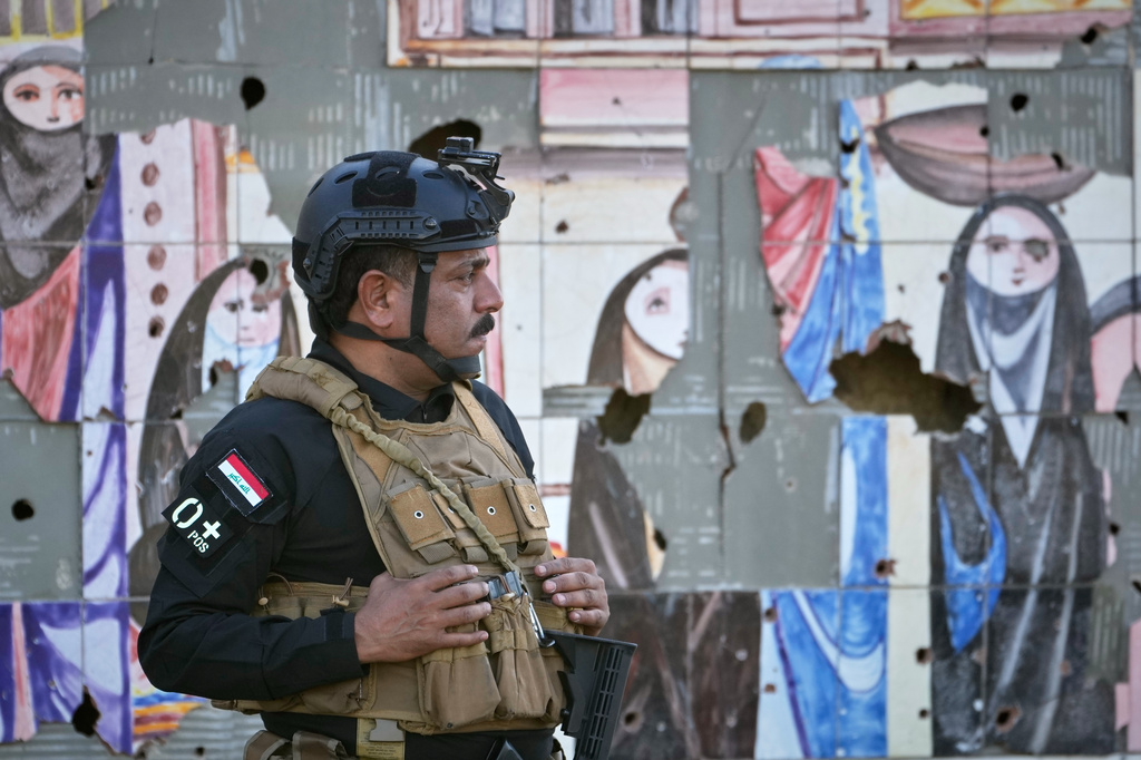 An Iraqi security officer stands guard at the site near Baghdad International Airport where Iranian military commander Qassem Soleimani was killed in a U.S. drone strike, during a visit by Iranian Parliament Speaker Mohammad Baqer Qalibaf in Baghdad, Iraq, Wednesday, Aug. 19, 2026. (AP Photo/Hadi Mizban)