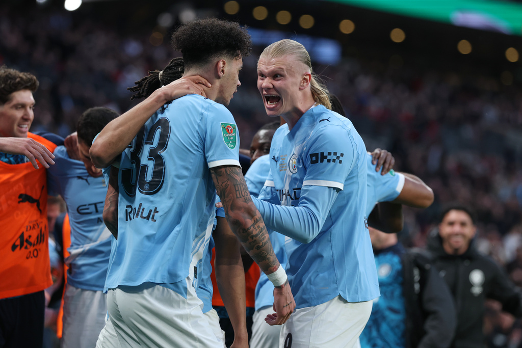 Manchester City's Nico O'Reilly celebrates with Erling Haaland, right, after scoring the opening goal during the English League Cup final soccer match between Arsenal and Manchester City in London, Sunday, March 22, 2026. (AP Photo/Richard Pelham)