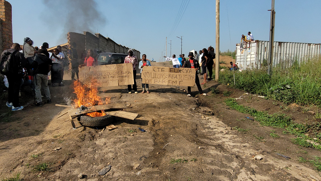 Rubble is set on fire as health and frontline workers protest at the Elikya Ebola Treatment Center in Bunia, Congo, on Saturday, July 25, 2026. (AP Photo/Constant Same Bagalwa)