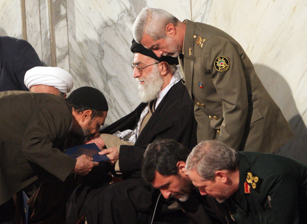 FILE - An unidentified man kisses the hand of Iran's Supreme Leader Ayatollah Ali Khamenei, as Iranian Army Commander Ataollah Salehi, right standing, Major Gen. Yahya Rahim Safavi, the Commander of Islamic Revolutionary Guards Corps (IRGC), right bottom, and Culture Islamic Guidance Minister Mohammad Hossein Saffar-Harandi, second right, attend a ceremony to commemorate those who died in a plane crash in Tehran, Iran, Dec. 10, 2005. (AP Photo/Hasan Sarbakhshian, File)