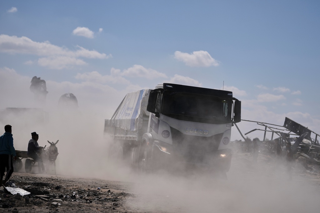 Trucks carrying aid from the World Food Programme (WFP) drive through in Khan Younis, southern Gaza Strip, Wednesday, Oct. 15, 2025. (AP Photo/Jehad Alshrafi)