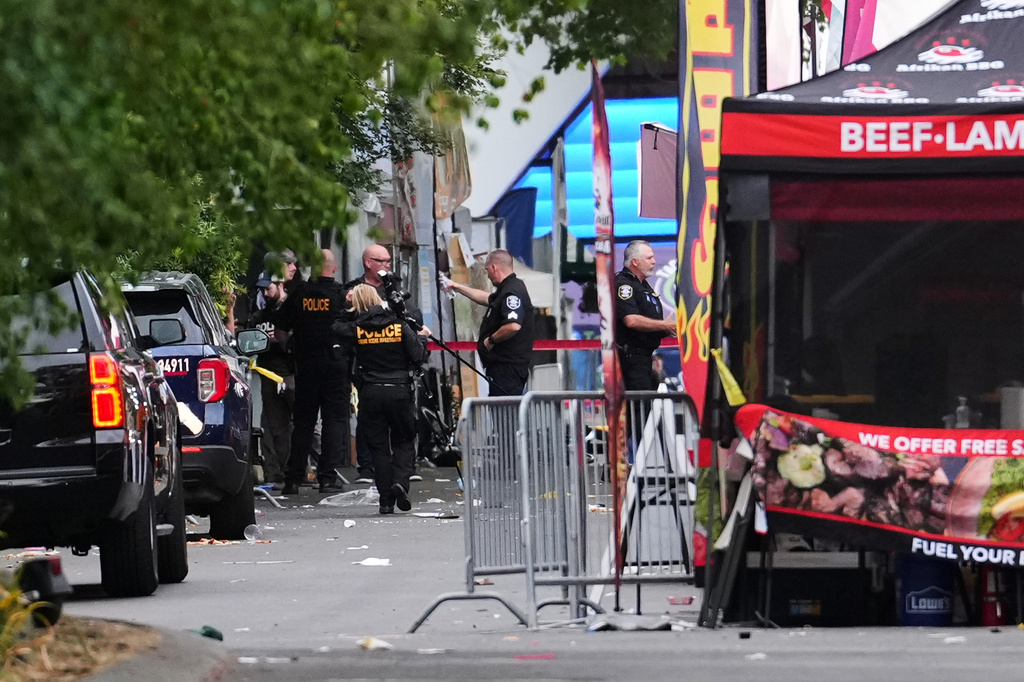 A crime scene photographer arrives as law enforcement examines the scene following a shooting at Seattle Center during the Bite of Seattle food festival Sunday, July 26, 2026, in Seattle. (AP Photo/Lindsey Wasson)