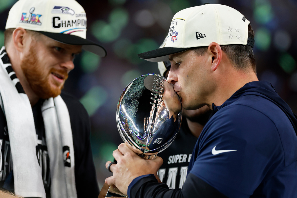 Seattle Seahawks head coach Mike Macdonald kisses the Lombardi Trophy as quarterback Sam Darnold (14) looks on after the Seahawks defeated the New England Patriots in the Super Bowl 60 in Santa Clara, Calif., Sunday, Feb. 8, 2026. (Scott Strazzante/San Francisco Chronicle via AP)
