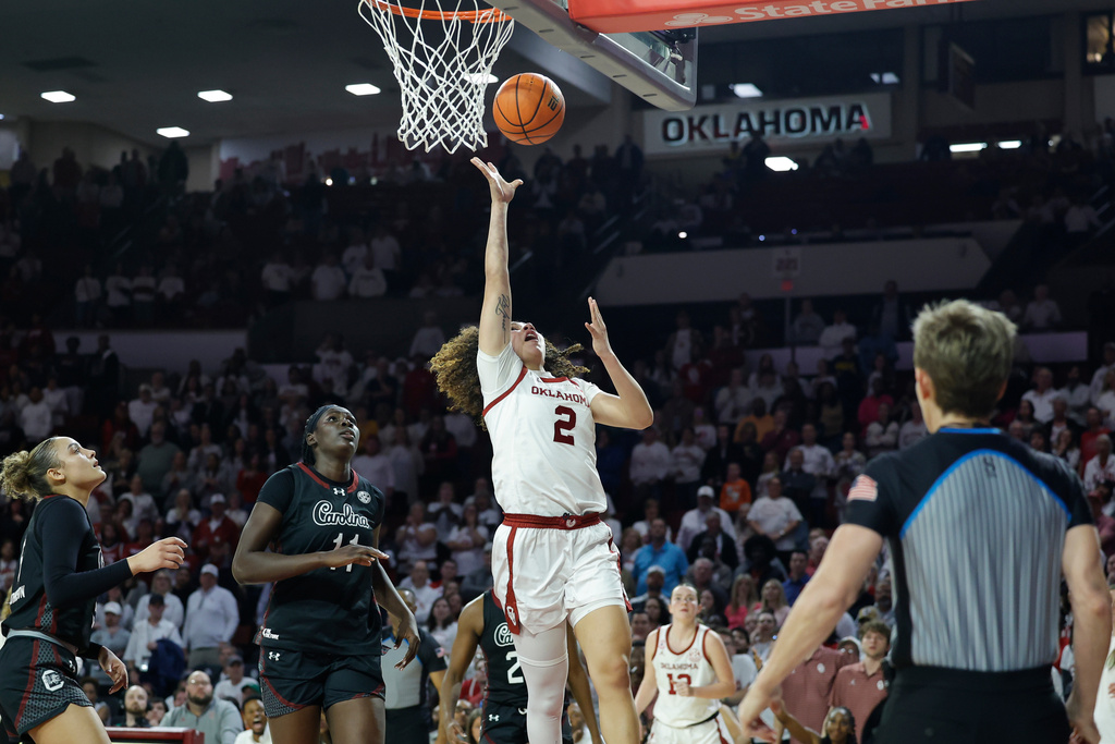 Oklahoma guard Aaliyah Chavez (2) goes up for a basket beside South Carolina center Madina Okot (11) during overtime of a NCAA college basketball game Thursday, Jan. 22, 2026 in Norman, Okla. (AP Photo/Alonzo Adams)