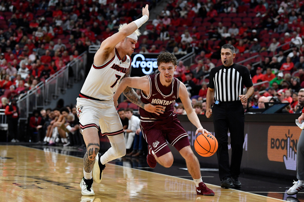 Montana guard Grant Kepley (11) drives against Louisville forward Kasean Pryor (7) during the first half of an NCAA college basketball game in Louisville, Ky., Saturday, Dec. 20, 2025. (AP Photo/Timothy D. Easley)
