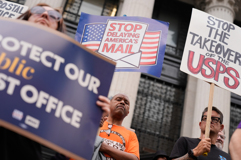 Postal workers and their supporters rally in front of a post office in New York, Tuesday, July 28, 2026. (AP Photo/Seth Wenig)