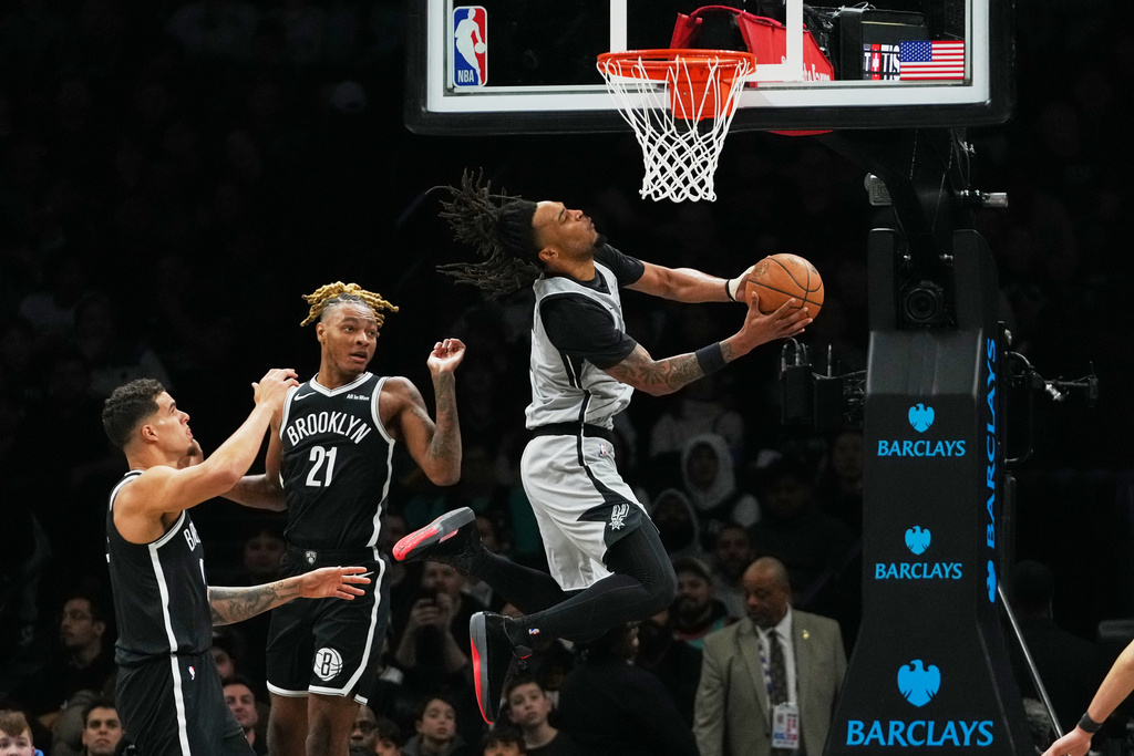 San Antonio Spurs' Stephon Castle, right, drives past Brooklyn Nets' Noah Clowney, center, and Michael Porter Jr. during the first half of an NBA basketball game Thursday, Feb. 26, 2026, in New York. (AP Photo/Frank Franklin II)