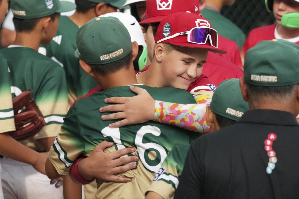 Taiwan's Liu Wei-Heng, center left, gets a hug from Las Vegas, Nev.'s Garrett Gallegos, center right, in the handshake line following the Little League World Series Championship baseball game in South Williamsport, Pa., Sunday, Aug. 24, 2025. (AP Photo/Gene J. Puskar)