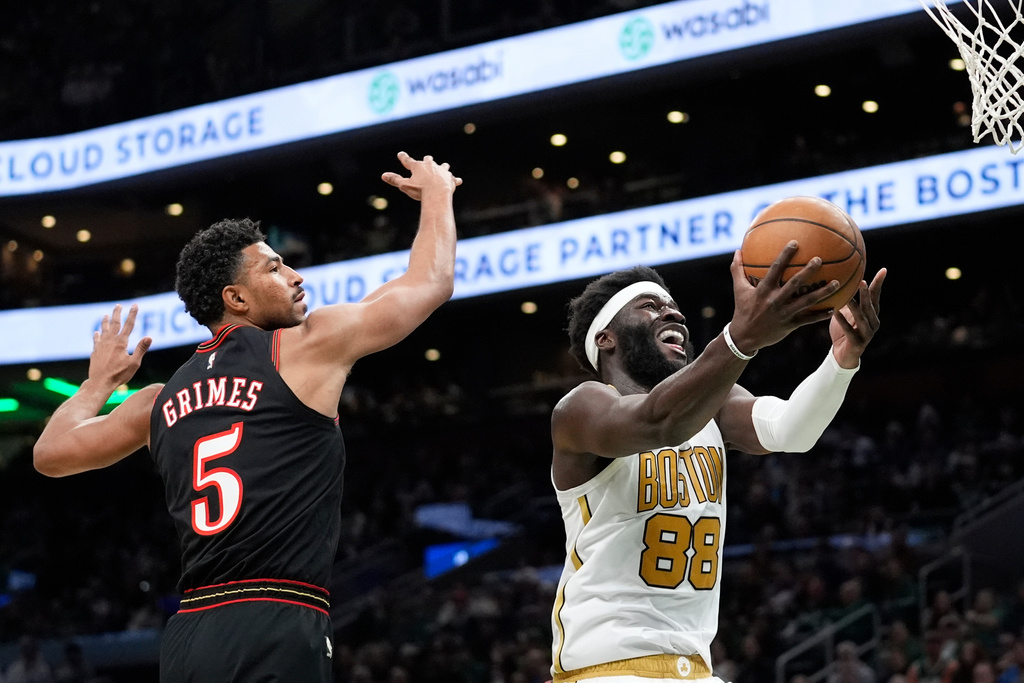 Boston Celtics center Neemias Queta (88) goes in for a lay up by Philadelphia 76ers guard Quentin Grimes (5) during the first half of an NBA basketball game, Sunday, March 1, 2026, in Boston. (AP Photo/Robert F. Bukaty)