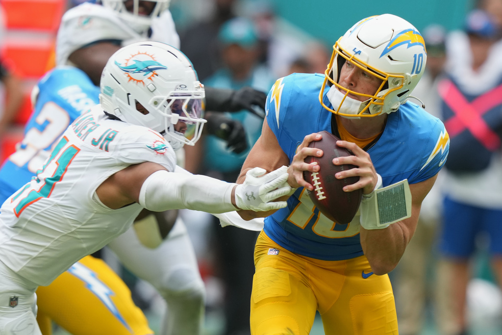 Los Angeles Chargers quarterback Justin Herbert, gets away from Miami Dolphins safety Dante Trader Jr. during the second half of an NFL football game Sunday, Oct. 12, 2025, in Miami Gardens, Fla. (AP Photo/Lynne Sladky)