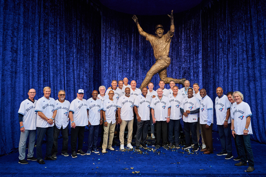 Toronto Blue Jays' Joe Carter, centre, is joined by members of the 1992 and 1993 Blue Jays at the unveiling of a statue commemorating the Toronto Blue Jays' 1992 and 1993 World Series wins ahead of a baseball game against the Chicago White Sox in Toronto, Saturday, July 18, 2026. (Sammy Kogan/The Canadian Press via AP)