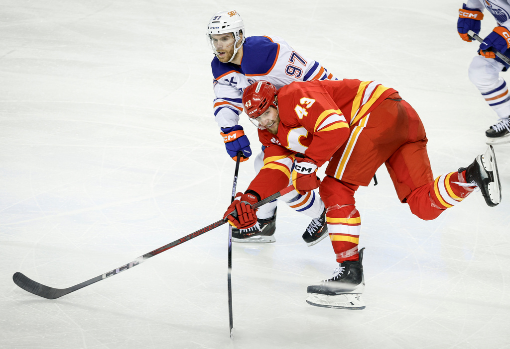 Edmonton Oilers' Connor McDavid (97) checks Calgary Flames' Adam Klapka during the third period of an NHL hockey game in Calgary, Alberta, Saturday, Dec. 27, 2025. (Jeff McIntosh/The Canadian Press via AP)
