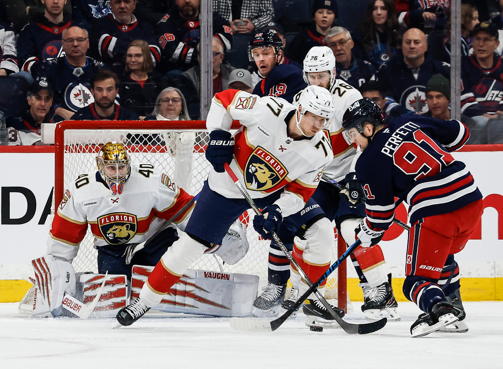Florida Panthers' Niko Mikkola (77) defends against Winnipeg Jets' Cole Perfetti (91) the first period of an NHL hockey game in Winnipeg, Thursday, Jan. 22, 2026. (John Woods/The Canadian Press via AP)