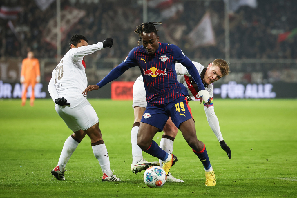 Leipzig's Yan Diomande, center, battles for the ball with St. Pauli's Eric Smith, right, and Joel Chima Fujita battle for the ball during the German Bundesliga soccer match between FC St. Pauli and RB Leipzig in Hamburg, Germany, Tuesday, Jan. 27, 2026. (Christian Charisius/dpa via AP)