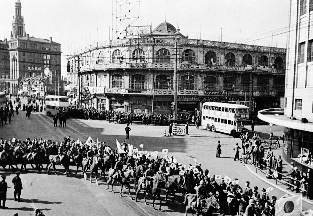 FILE - When 5,000 Japanese soldiers took part in a victory parade through the international settlement in Shanghai, China, on Dec. 3, 1937, with machine guns and artillery, a Chinese person threw a hand-grenade at the marching throng, and several Japanese were injured. Japanese cavalry swings into Nanking Road with banners flying. Just after this stage the hand grenade was thrown, causing confusion among the marching troops. (AP Photo, File)