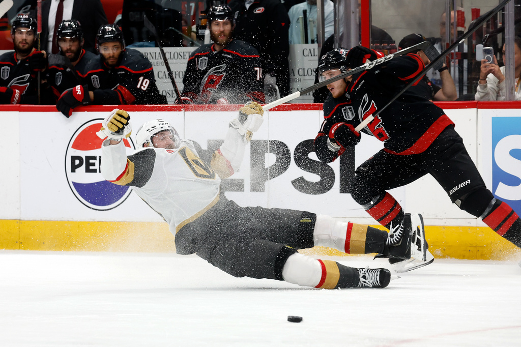 Carolina Hurricanes' Alexander Nikishin, right, checks Vegas Golden Knights' Colton Sissons, left, during the third period in Game 5 of the NHL hockey Stanley Cup Final series in Raleigh, N.C., Thursday, June 11, 2026. (AP Photo/Karl DeBlaker)