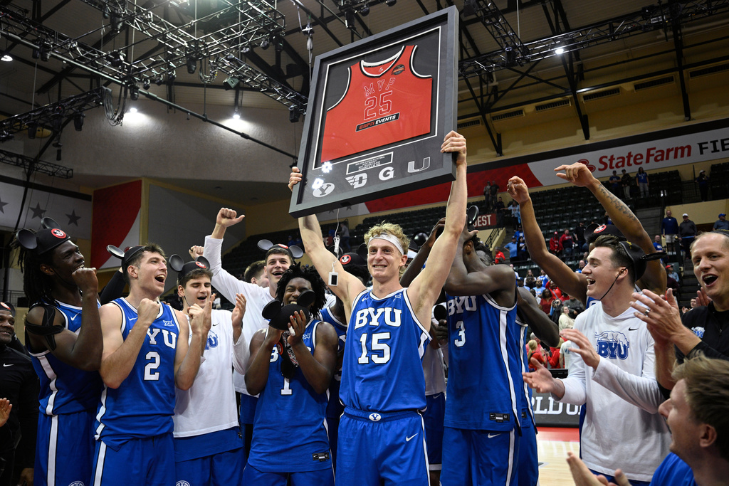 BYU guard Richie Saunders (15) raises a framed jersey after being named the tournament MVP after his team's win over Dayton in an NCAA college basketball game, Friday, Nov. 28, 2025, in Kissimmee, Fla. (AP Photo/Phelan M. Ebenhack)