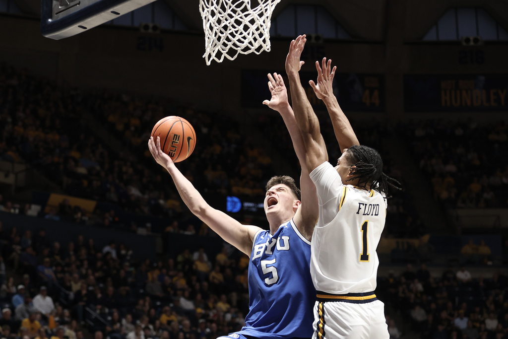 BYU forward Mihailo Boskovic (5) shoots while being defended by West Virginia guard Jasper Floyd (1) during the first half of an NCAA college basketball game Saturday, Feb. 28, 2026, in Morgantown, W.Va. (AP Photo/Kathleen Batten)