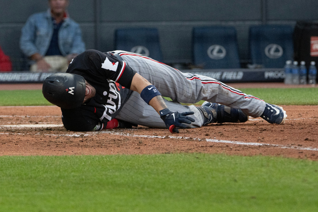 Minnesota Twins' Victor Caratini reacts after fouling a pitch from Cleveland Guardians starting pitcher Slade Cecconi off his leg during the fifth inning of a baseball game, Wednesday, July 22, 2026, in Cleveland. (AP Photo/Phil Long)