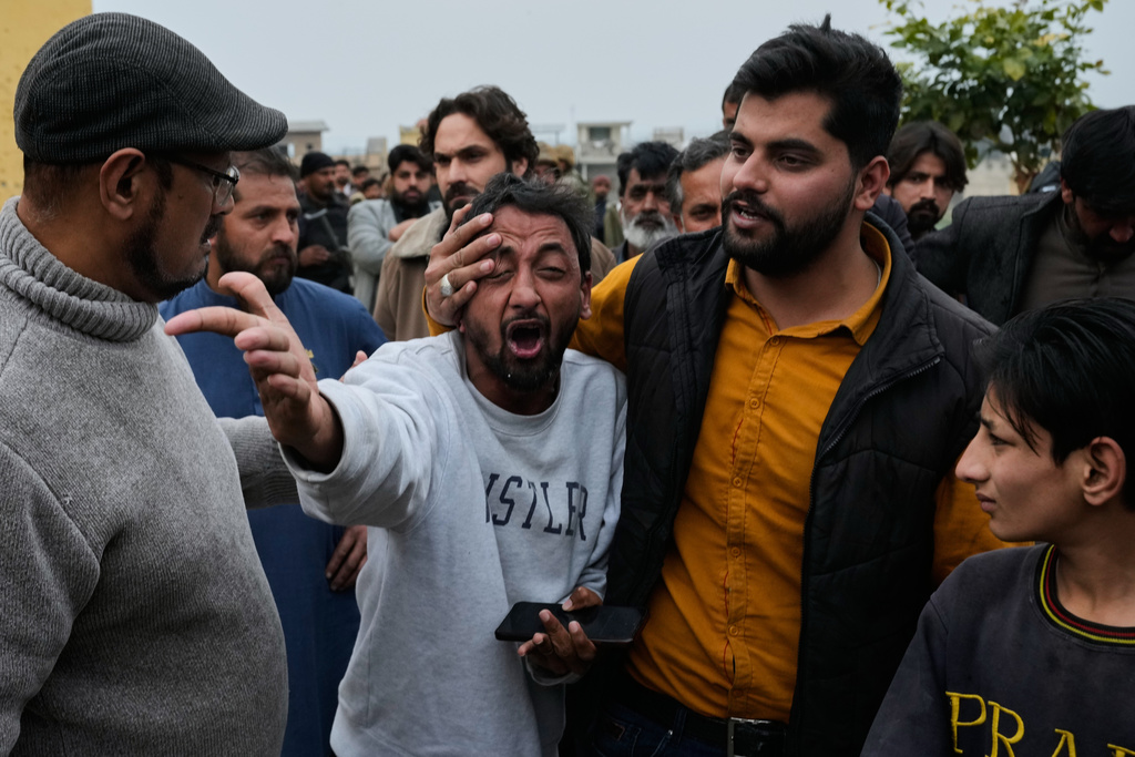 People comfort a man, center, mourning over the death of his relative, close to the site of a bomb explosion at a Shiite mosque, in Islamabad, Pakistan, Friday, Feb. 6, 2026. (AP Photo/Anjum Naveed)