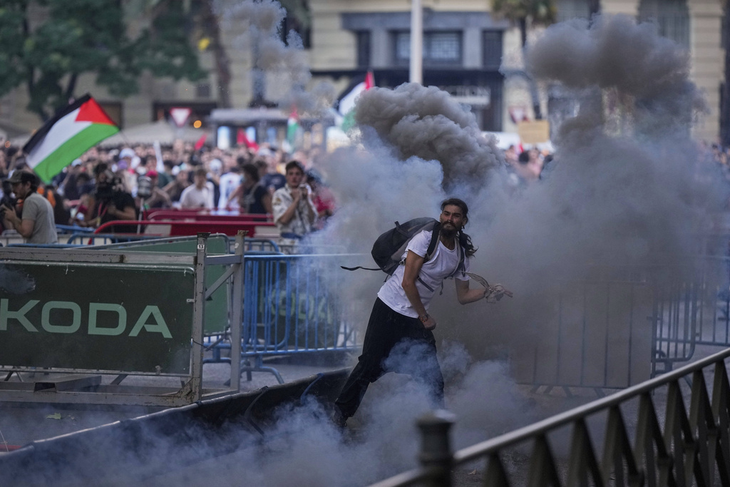 Protesters clash with police as they block the road trying to disrupt the twenty-first stage of the Spanish cycling race La Vuelta, from Alalpardo to Madrid, Spain, Sunday, Sept. 14, 2025. (AP Photo/Manu Fernández)