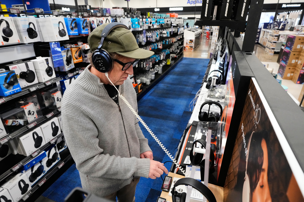 Chad Cook of Dallas, tries checks out a headphone unit as he shops at a Best Buy store, Wednesday, Nov. 26, 2025, in Dallas. (AP Photo/Tony Gutierrez)