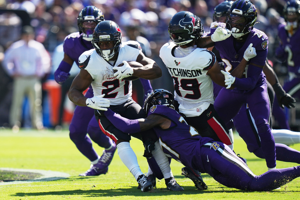 Houston Texans running back Nick Chubb (21) is tackled by Baltimore Ravens cornerback T.J. Tampa (27) during the first half of an NFL football game, Sunday, Oct. 5, 2025, in Baltimore. (AP Photo/Stephanie Scarbrough)