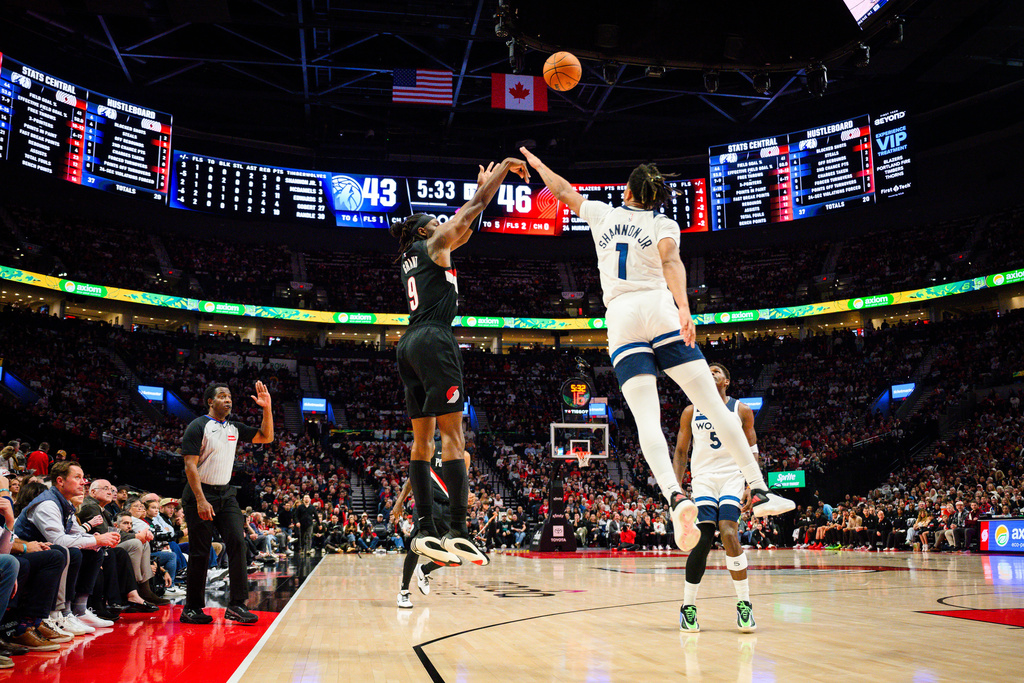 Portland Trail Blazers forward Jerami Grant (9) shoots a three-pointer past Minnesota Timberwolves guard/forward Terrence Shannon Jr. (1) during the first half of an NBA basketball game on Wednesday, Oct. 22, 2025, in Portland, Ore. (AP Photo/Molly J. Smith)