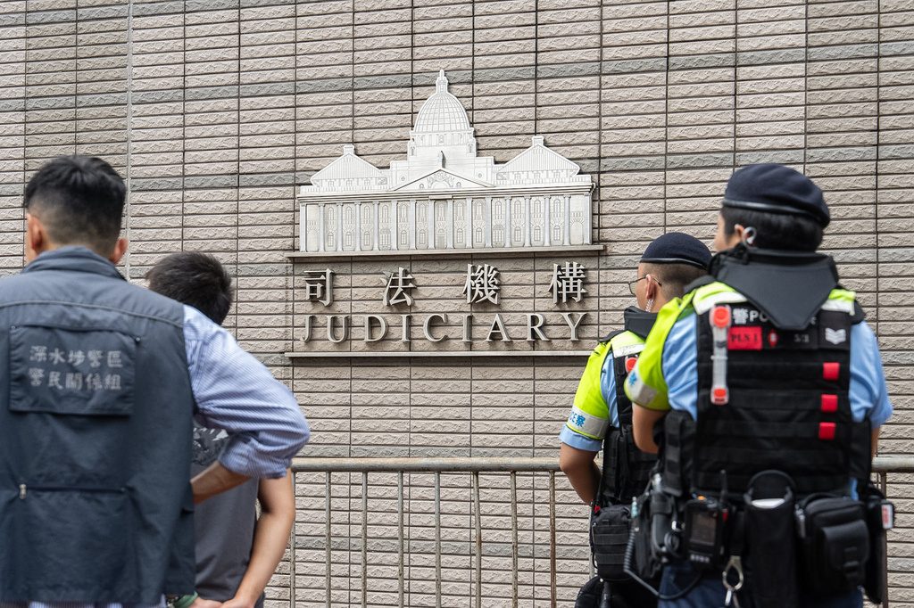 Police officers stand guard outside the West Kowloon Magistrates' Courts in Hong Kong, Friday, Aug. 21, 2026. (AP Photo/Chan Long Hei)