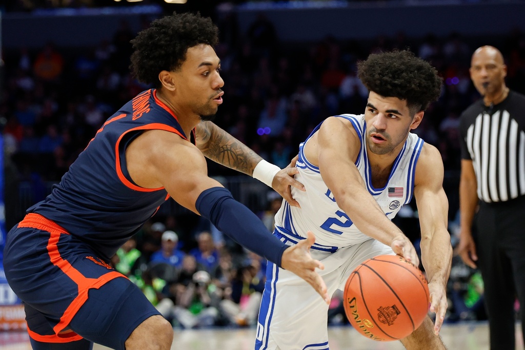 Duke guard Cayden Boozer (2) passes the ball around Virginia guard Malik Thomas, left, during the first half of an NCAA college basketball game in the championship of the Atlantic Coast Conference tournament in Charlotte, N.C., Saturday, March 14, 2026. (AP Photo/Nell Redmond)