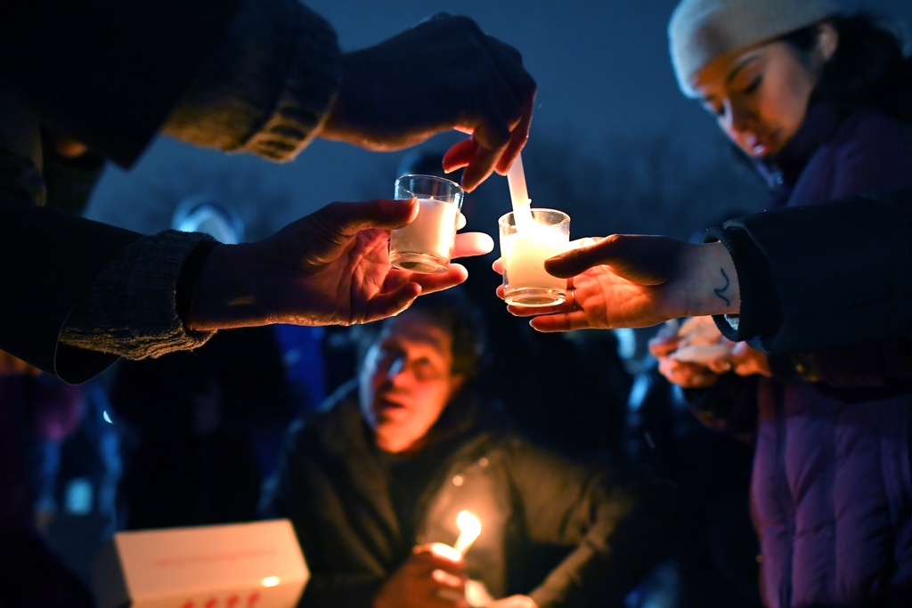 People light candles at the beginning of a vigil, Sunday, Dec. 14, 2025, in Providence, R.I., for those injured or killed during the Saturday shooting on the campus of Brown University. (AP Photo/Steven Senne)