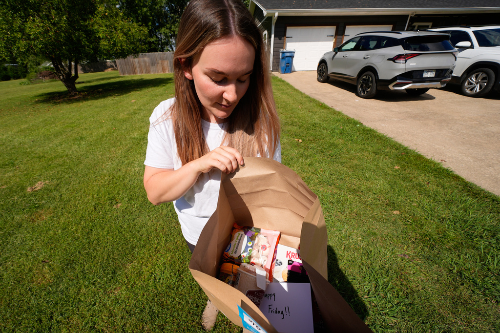 Emily Ingram checks her Walmart order after it was delivered by a drone operated by Zipline in Pea Ridge, Ark., Friday, Sept. 26, 2025. (AP Photo/Charlie Riedel)