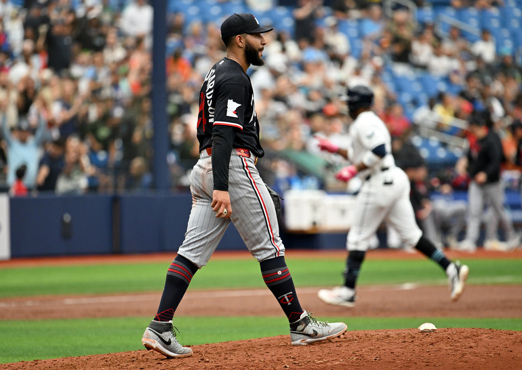 Minnesota Twins pitcher Simeon Woods Richardson walks back to the mound as Tampa Bay Rays' Yandy Díaz rounds the bases after his two-run home run during the third inning of a baseball game Sunday, April 26, 2026, in St. Petersburg, Fla. (AP Photo/Jason Behnken)