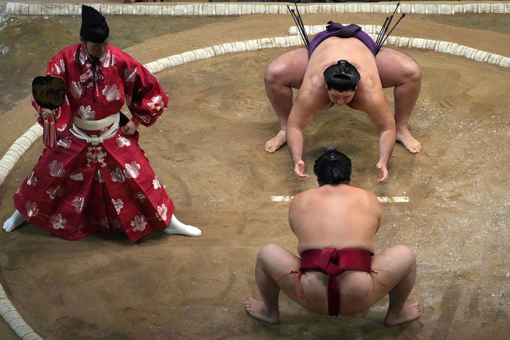 Sumo wrestlers Daieisho and Roga, facing, compete in a Grand Sumo Tournament bout on the dohyo, the sacred sumo wrestling ring, at the Royal Albert Hall in London, Sunday, Oct. 19, 2025. (AP Photo/Frank Augstein)