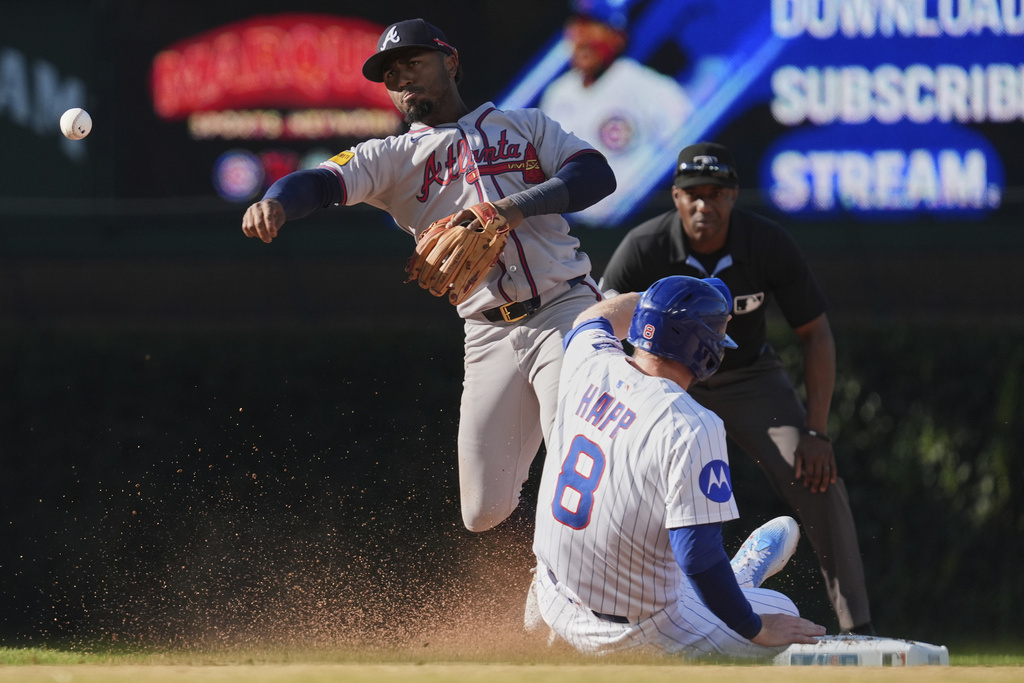 Atlanta Braves second baseman Ozzie Albies, left, throws to first base on a double play-attempt after forcing out Chicago Cubs' Ian Happ (8) during the sixth inning of a baseball game in Chicago, Monday, Sept. 1, 2025. (AP Photo/Nam Y. Huh)