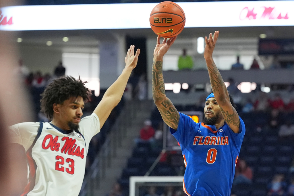 Florida guard Boogie Fland (0) attempts a 3-point shot over Mississippi guard Patton Pinkins (23) during the first half of an NCAA college basketball game, Saturday, Feb. 21, 2026, in Oxford, Miss. (AP Photo/Rogelio V. Solis)