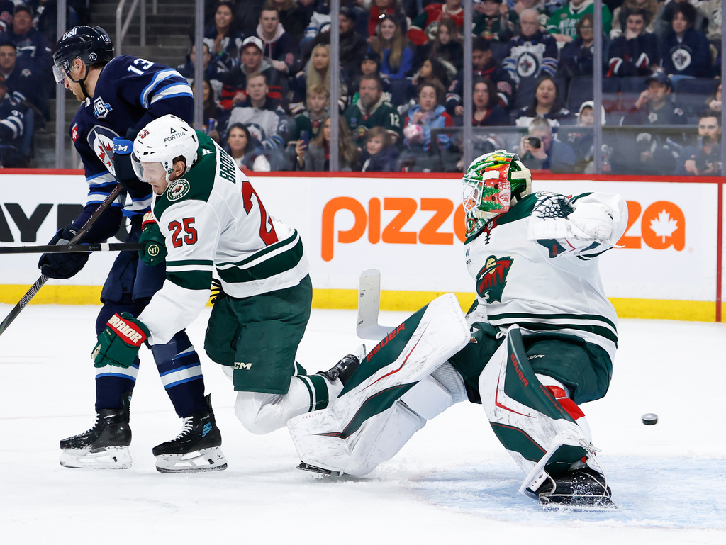 Minnesota Wild's Jonas Brodin (25) and goaltender Jesper Wallstedt (30) collide during the second period of an NHL hockey game in Winnipeg, Manitoba, Saturday, Dec. 27, 2025. (John Woods/The Canadian Press via AP)