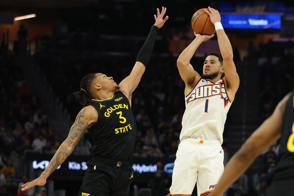 Phoenix Suns guard Devin Booker (1) looks to shoot against Golden State Warriors guard Will Richard (3) during the first half of an NBA basketball game in San Francisco, Saturday, Dec. 20, 2025. (AP Photo/Jed Jacobsohn)