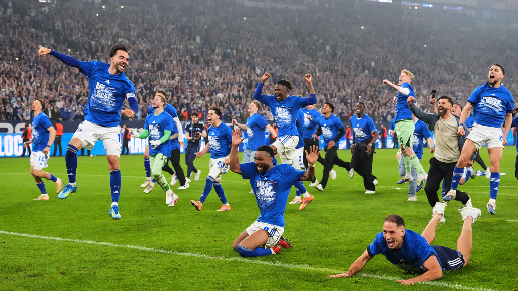 Schalke's Kenan Karaman, left, celebrates with his team after FC Schalke 04 secured promotion to the German Bundesliga by winning the Bundesliga 2 match against Fortuna Duesseldorf at the Arena in Gelsenkirchen, Germany, Saturday, May 2, 2026. (AP Photo/Martin Meissner)