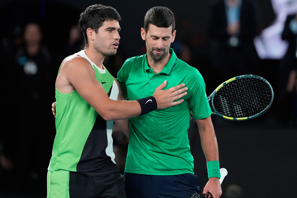 Carlos Alcaraz of Spain, left, and Novak Djokovic of Serbia embrace after Alcaraz won the men's singles final at the Australian Open tennis championship in Melbourne, Australia, Sunday, Feb. 1, 2026. (AP Photo/Asanka Brendon Ratnayake)