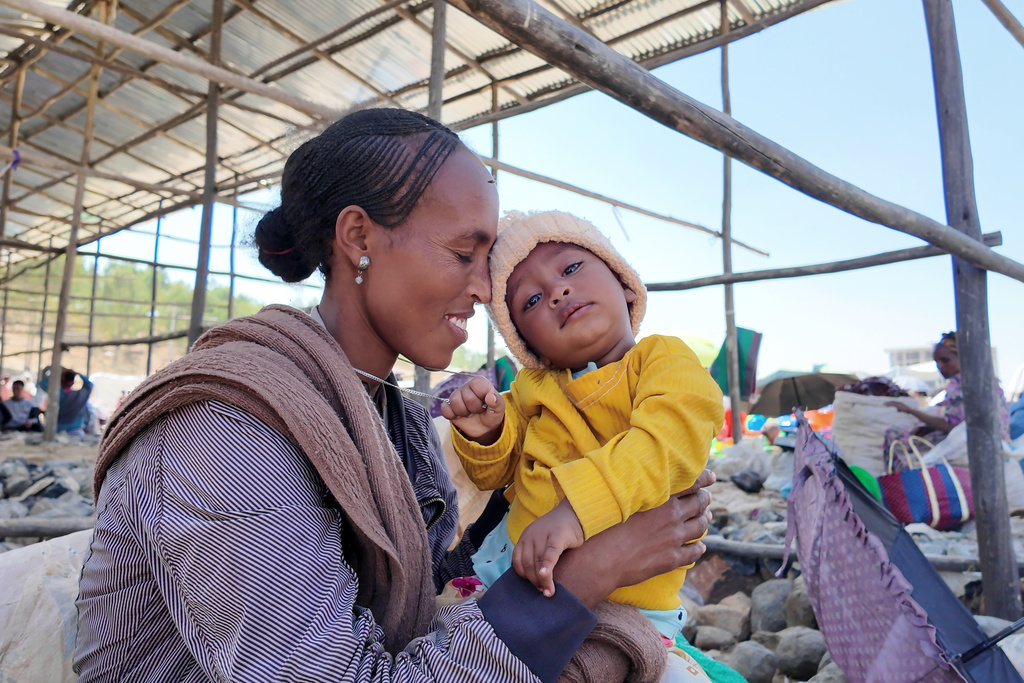 A woman holds her child at a street market in Wukro in the Tigray region of northern Ethiopia, Tuesday, Jan. 27, 2026. (AP Photo/Jody Ray)