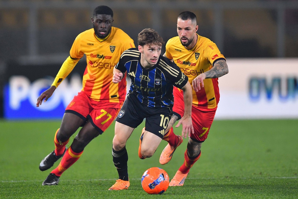 Matteo Tramoni (10) dribbles ahead of Lecce's Mohamed Kaba Pisa (77) and Mehdi Léris (7) during a Serie A soccer match between US Lecce and Pisa Sportin Club 1909, Friday, Dec. 12, 2025, in Lecce, Italy. (Giovanni Evangelista/LaPresse via AP)