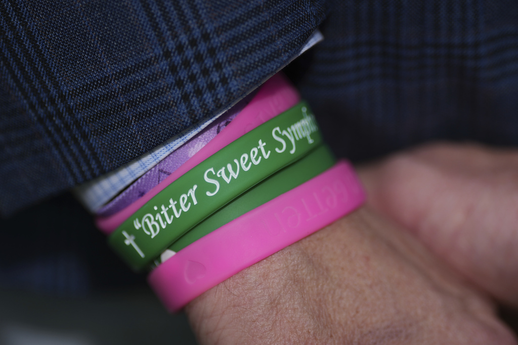 A parent of child who died at Camp Mystic wears a memory bracelet as he joins Texas Gov. Greg Abbott who signed camp safety bills, Friday, Sept. 5, 2025, in Austin, Texas. (AP Photo/Eric Gay)
