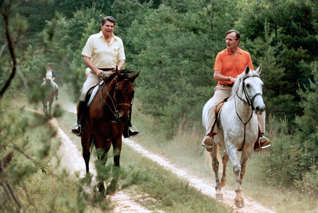 FILE - In this July 1981 file photo released by The White House, U.S. President Ronald Reagan, left, and Vice President George Bush go horseback riding at Camp David, Md. (Michael Evans/The White House, via AP, File)
