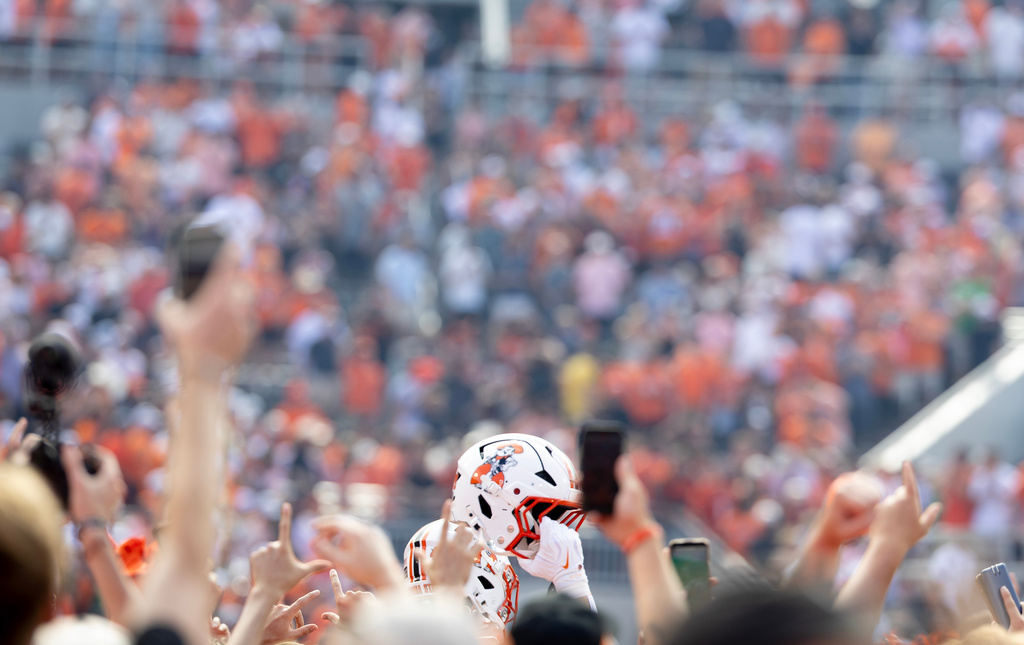 An Oklahoma State helmet is held up after fans rushed the field after the NCAA college football game Oregon in Stillwater, Okla., Saturday, Sept. 12, 2026. (AP Photo/Mitch Alcala)