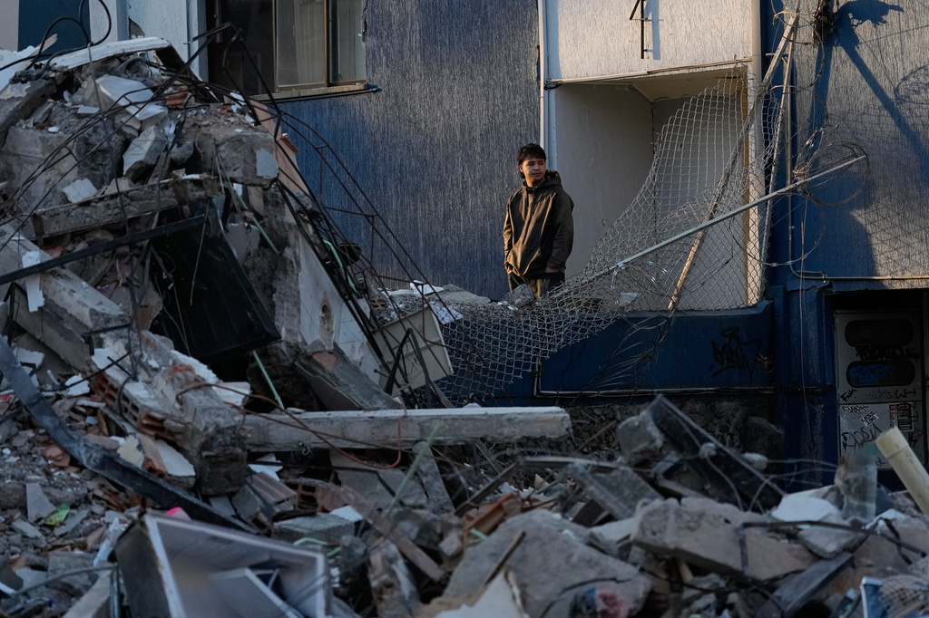 A neighbor looks at a collapsed building the day after and earthquake struck Pereira, Colombia, Tuesday, Aug. 11, 2026. (AP Photo/Fernando Vergara)