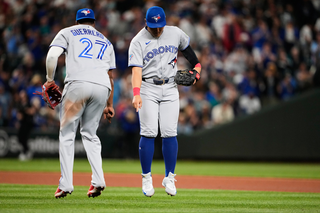 Toronto Blue Jays first baseman Vladimir Guerrero Jr. celebrates with third baseman Kazuma Okamoto, facing, after a win over the Seattle Mariners in a baseball game, Friday, July 3, 2026, in Seattle. (AP Photo/Lindsey Wasson)