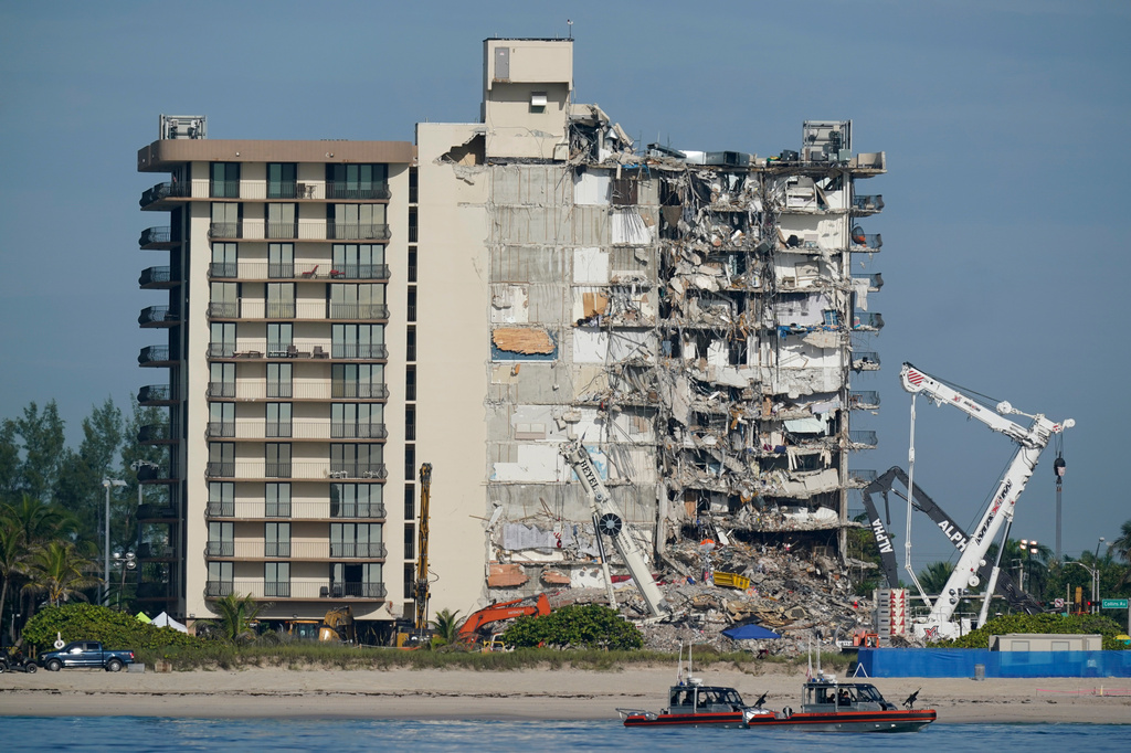 FILE - Coast Guard boats patrol in front of the partially collapsed Champlain Towers South condo building, July 1, 2021, in Surfside, Fla. (AP Photo/Mark Humphrey, File)